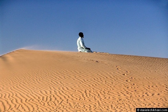 Mohammed praying in the dunes